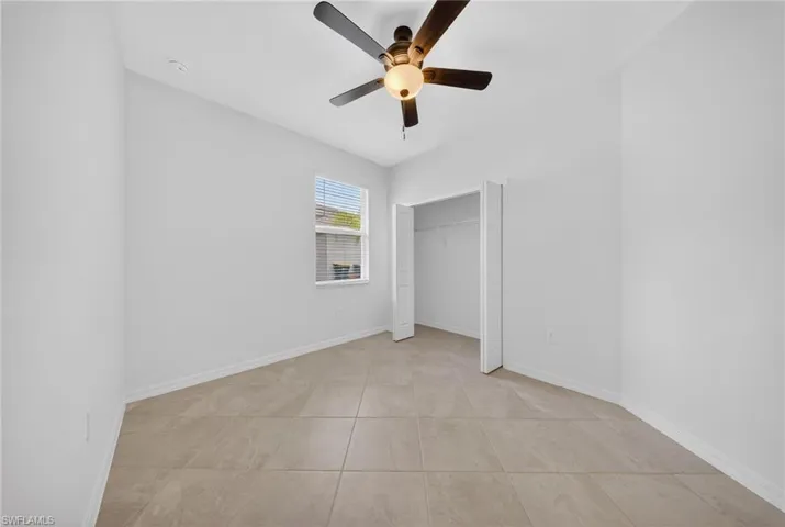 Unfurnished bedroom featuring ceiling fan and a closet