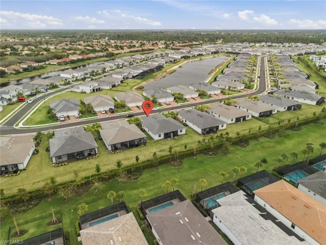 Aerial view of property and surrounding area featuring nearby suburban area and a nearby body of water