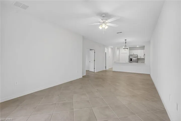 Unfurnished living room with ceiling fan and light tile patterned flooring