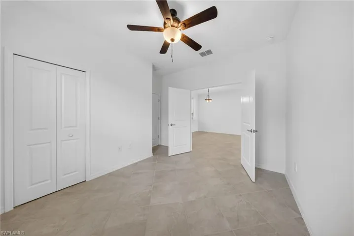 Unfurnished bedroom with a ceiling fan and a closet
