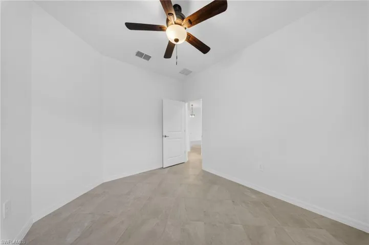 Spare room featuring ceiling fan and baseboards