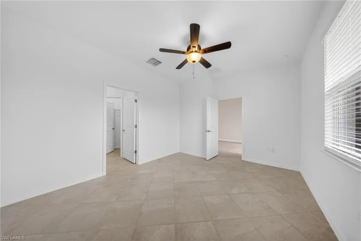 Unfurnished bedroom with a ceiling fan and baseboards