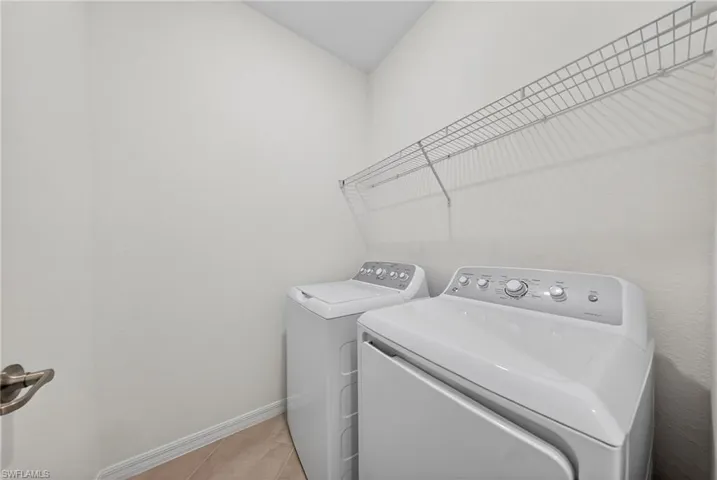 Laundry room with baseboards and washing machine and dryer