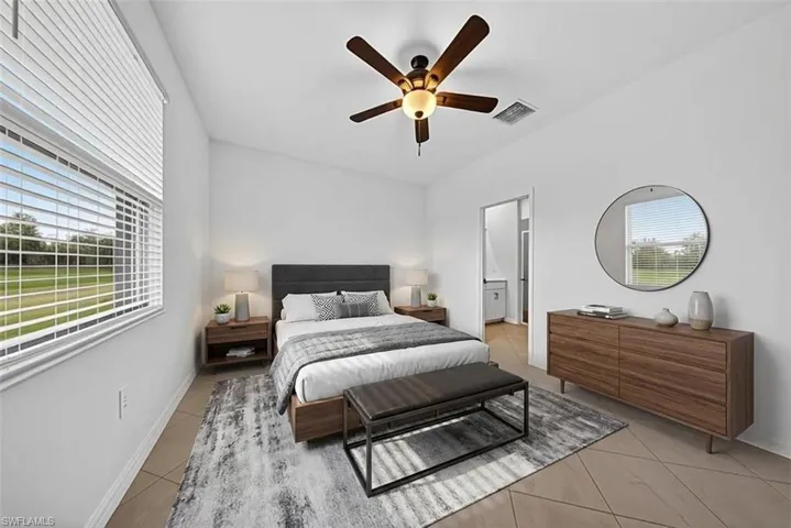 Bedroom featuring light tile patterned flooring, a ceiling fan, and ensuite bathroom