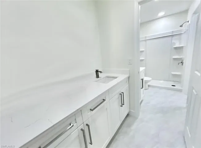 Bathroom with dual vanities, dual sinks, and shower