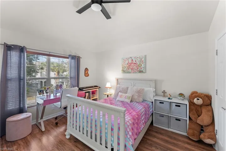 Bedroom with dark hardwood / wood-style flooring and ceiling fan