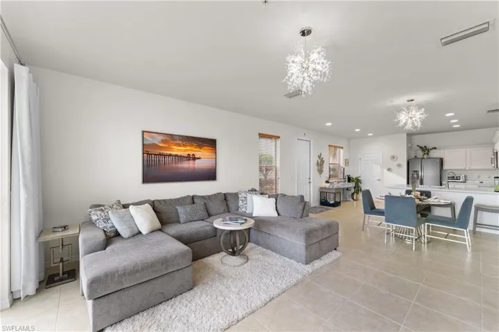 Living room featuring light tile patterned floors and a notable chandelier