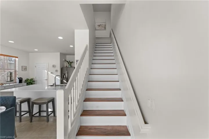Stairway featuring tile patterned floors and sink