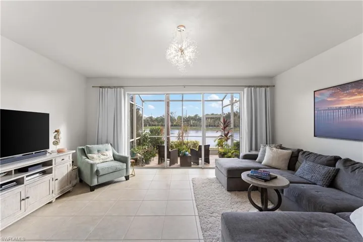 Living room featuring a chandelier, a water view, and light tile patterned flooring