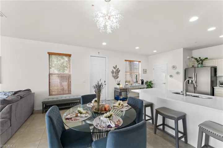 Tiled dining room featuring sink and an inviting chandelier