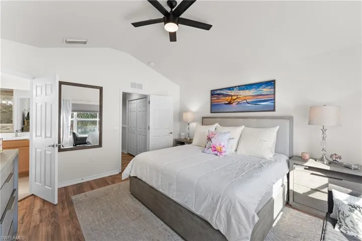 Bedroom with dark wood-type flooring, a closet, lofted ceiling, and ceiling fan
