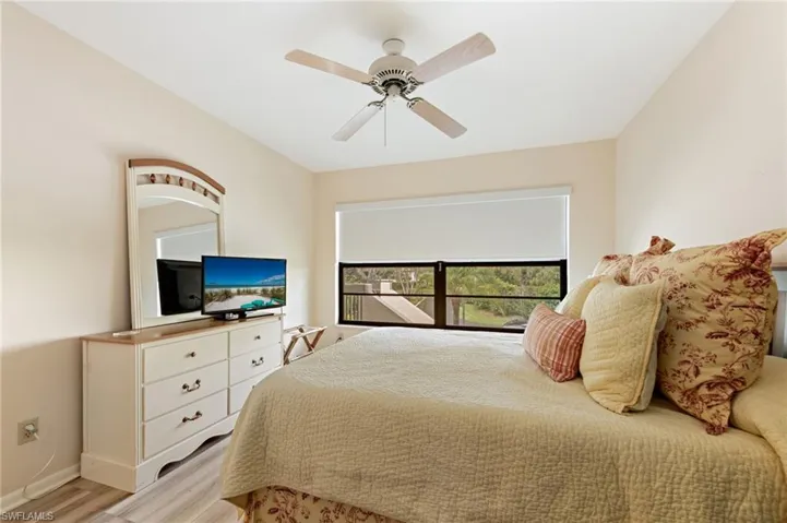 Neutral-toned room featuring CoreTec luxury vinyl plank flooring, a ceiling fan, and a large window with an installed roller shade