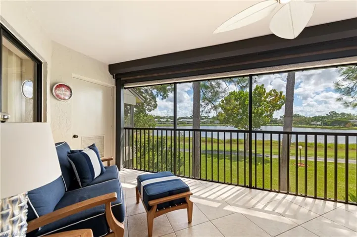 Screened-in Lanai featuring tile flooring, black metal railing, and a mounted ceiling fan