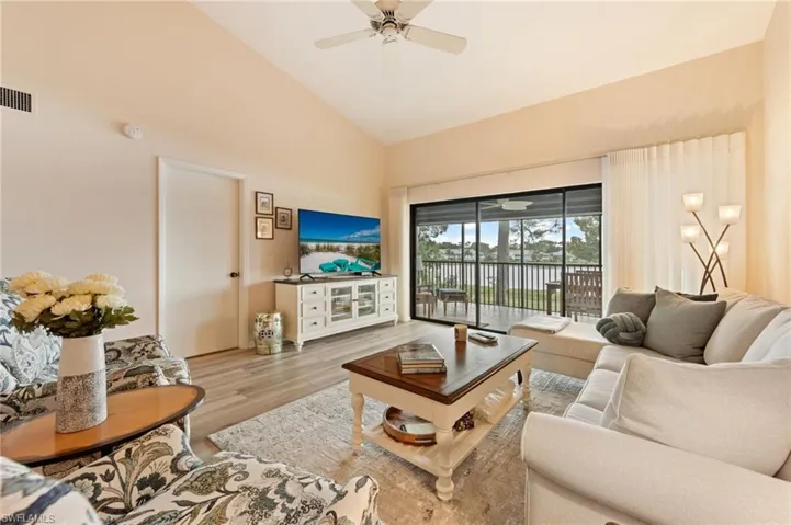 Vaulted ceilings with central fan and expansive sliding glass doors opening to an exterior screened patio
