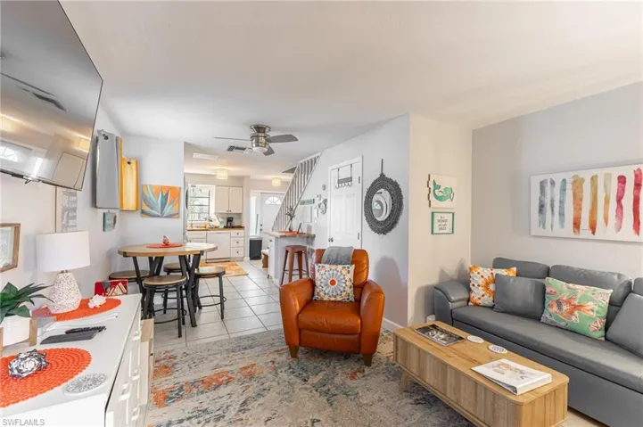 Living room with light tile patterned floors and a ceiling fan
