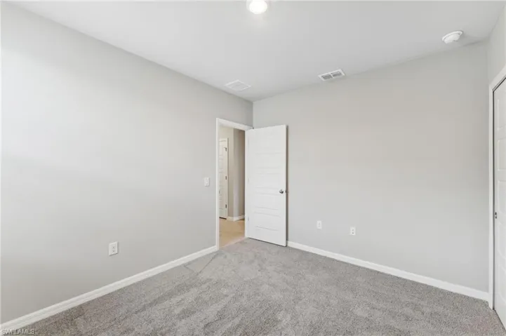 Empty room featuring light carpet