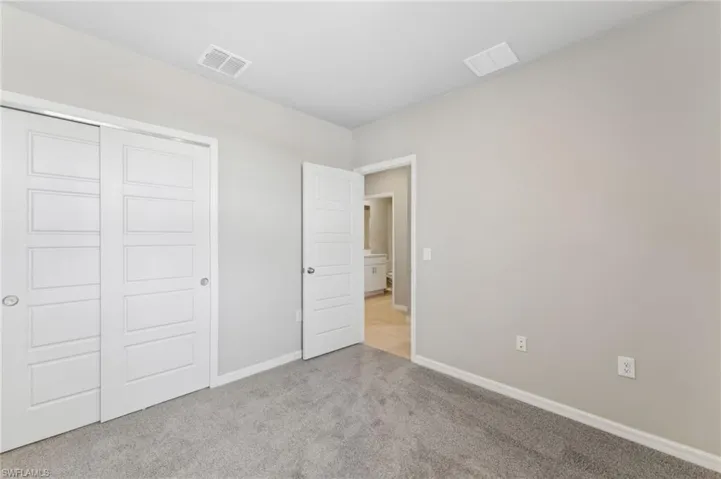 Unfurnished bedroom featuring light colored carpet and a closet