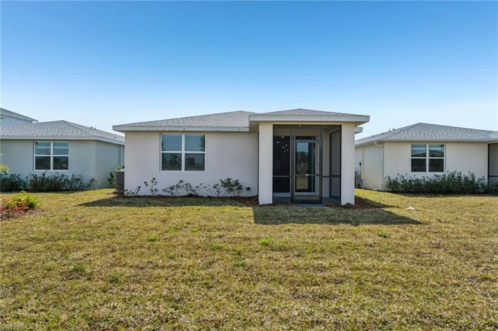 Back of property with a yard and a sunroom