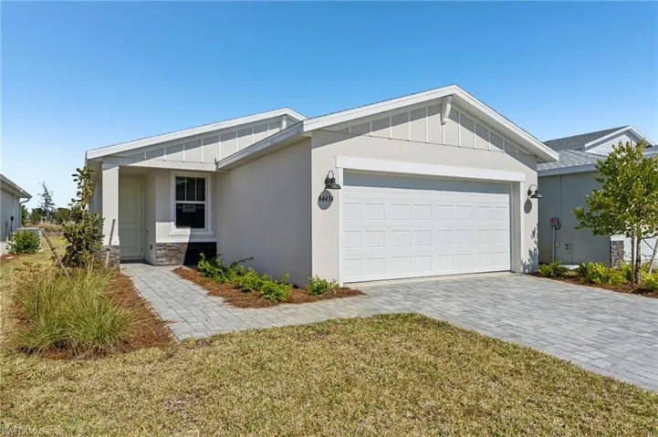 Ranch-style home featuring a garage and a front yard