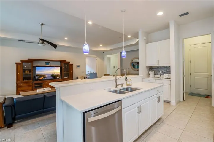 Bright room featuring two windows with white blinds and blue valances, light-colored tile flooring, and white walls