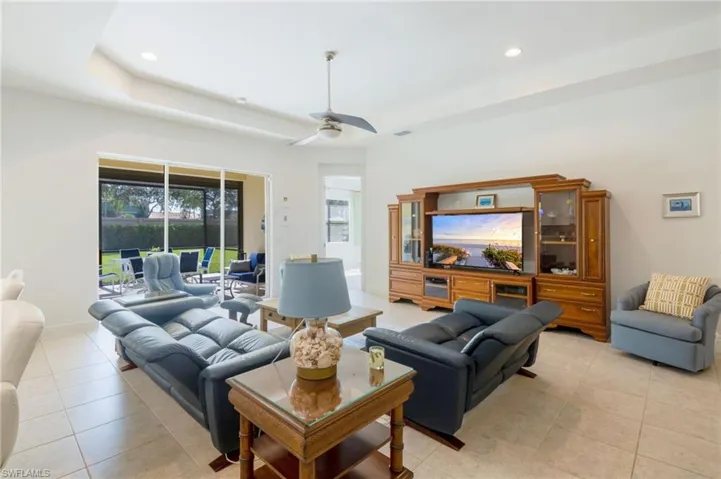 Open concept living area with tray ceiling and recessed lighting