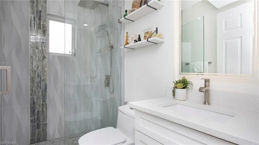 Full bath with vanity, a shower stall, and toilet