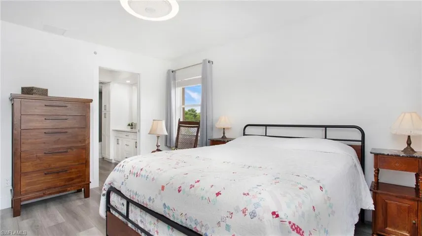 Bedroom featuring wood finished floors and ensuite bath