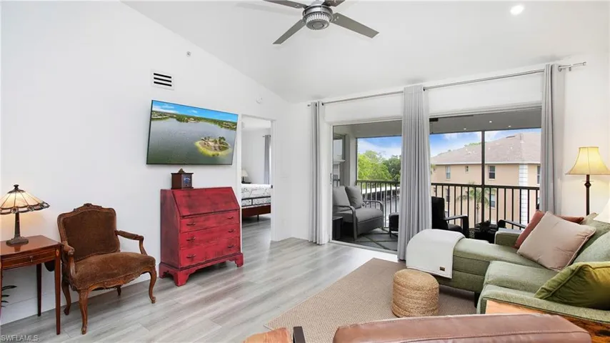 Living room featuring ceiling fan, light wood finished floors, and high vaulted ceiling