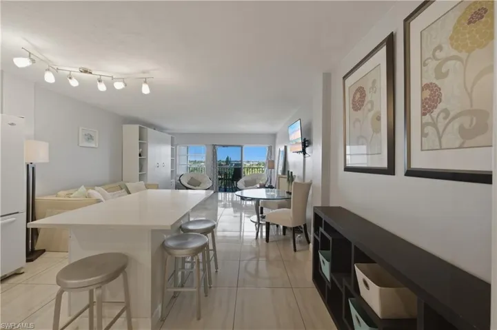 Kitchen featuring a kitchen breakfast bar, freestanding refrigerator, a center island, and light tile patterned floors