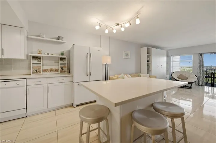 Kitchen featuring open shelves, light countertops, white appliances, white cabinets, and a center island