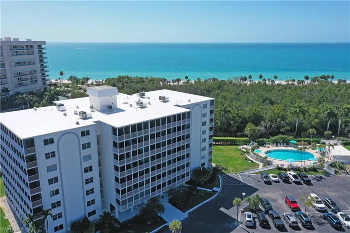 Drone / aerial view of a pool area and a nearby body of water