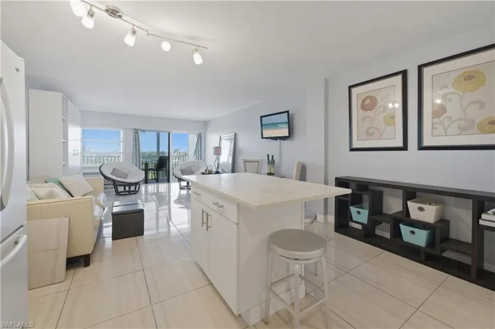 Kitchen with a center island, a breakfast bar area, open floor plan, and white cabinetry