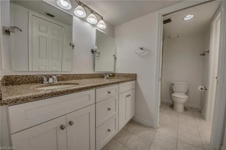Bathroom with tile  flooring, vanity, and toilet
