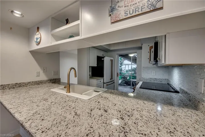 Kitchen with white cabinetry, white appliances, and decorative backsplash