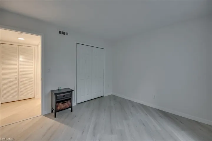 Second bedroom with wood-look tile floors and a closet