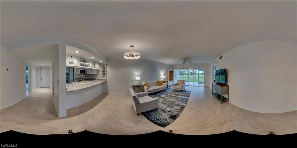 Living room featuring ceiling fan, lofted ceiling, sink, and light wood-type flooring
