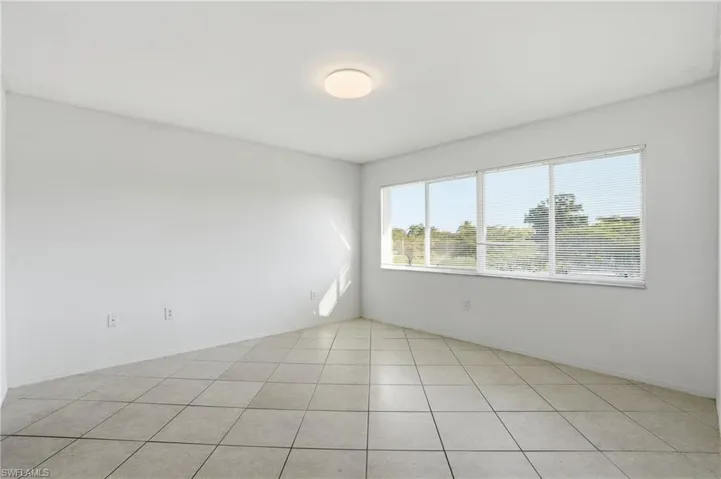 Empty room featuring light tile patterned flooring and baseboards