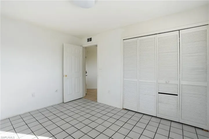 Unfurnished bedroom featuring a closet and light tile patterned floors