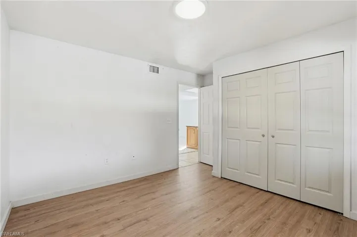 Unfurnished bedroom featuring light wood-type flooring and a closet