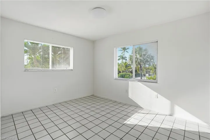 Empty room featuring plenty of natural light and tile patterned flooring