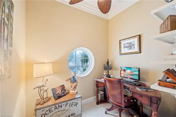 Tiled office with ornamental molding and a ceiling fan
