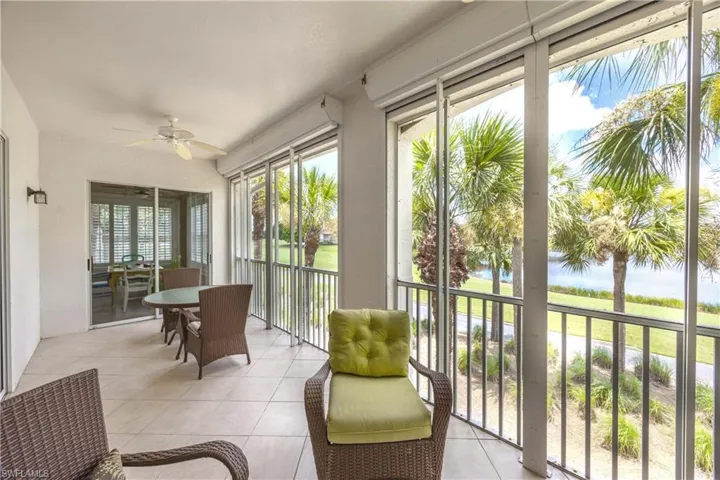Sunroom featuring a water view, ceiling fan, and tile patterned floors