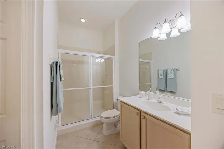 Full bath featuring tile patterned flooring, vanity, and a shower stall