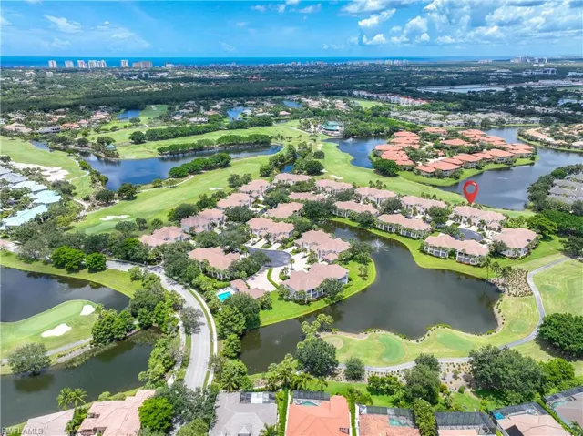 Aerial perspective of suburban area featuring a local golf course and a nearby body of water