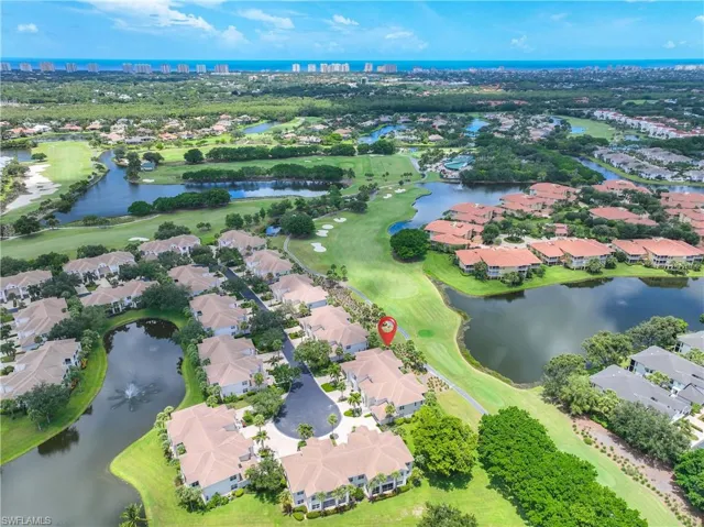 Aerial view of residential area with a nearby body of water and a golf club