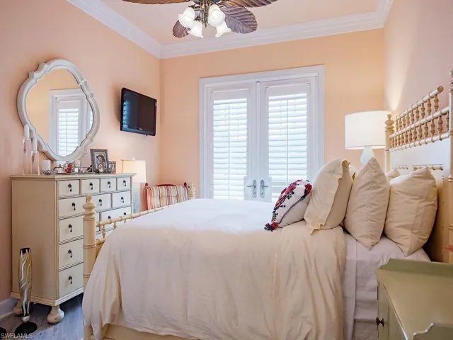 Dining space featuring a chandelier, ceiling fan, a tray ceiling, ornamental molding, and recessed lighting