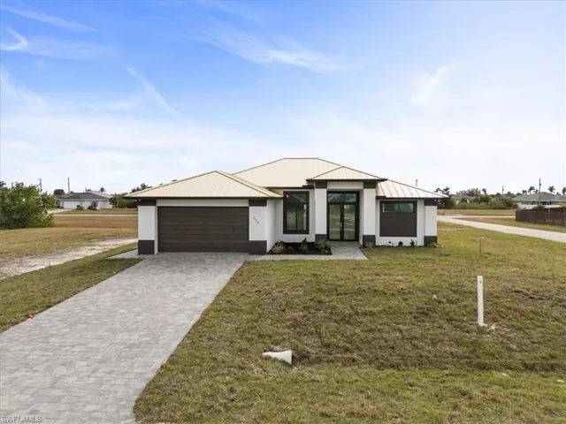 View of front facade featuring a front lawn and a garage