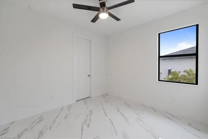 Unfurnished room featuring ceiling fan and a healthy amount of sunlight