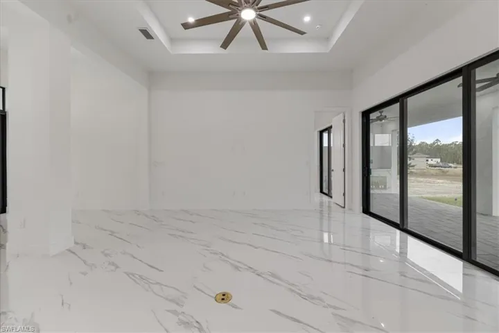 Unfurnished room featuring ceiling fan and a tray ceiling