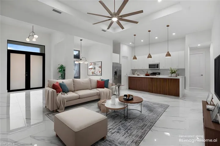 Living room with ceiling fan with notable chandelier and a tray ceiling